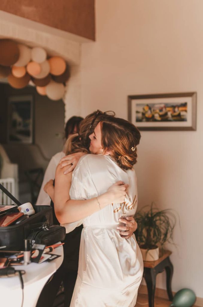 Préparatifs de mariage : la mariée enlace la maquilleuse pour la remercier