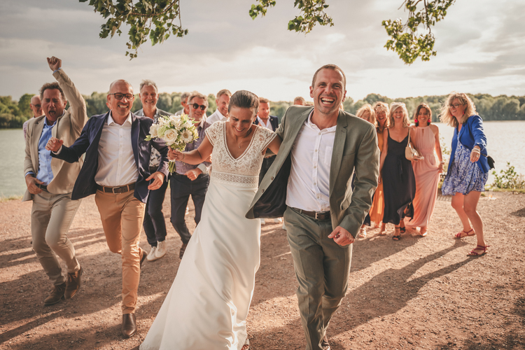 Un groupe de personnes participant à un mariage au bord d’un lac