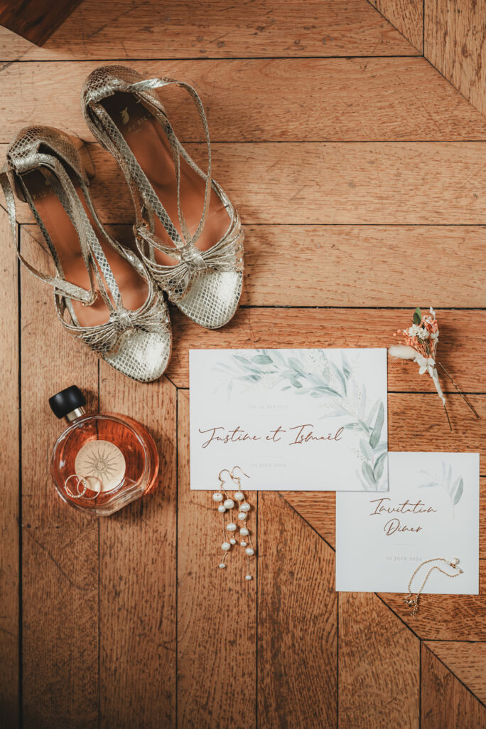 Alliances posées sur un flacon de parfum pour les détails de mariage de Justine et Ismaël.