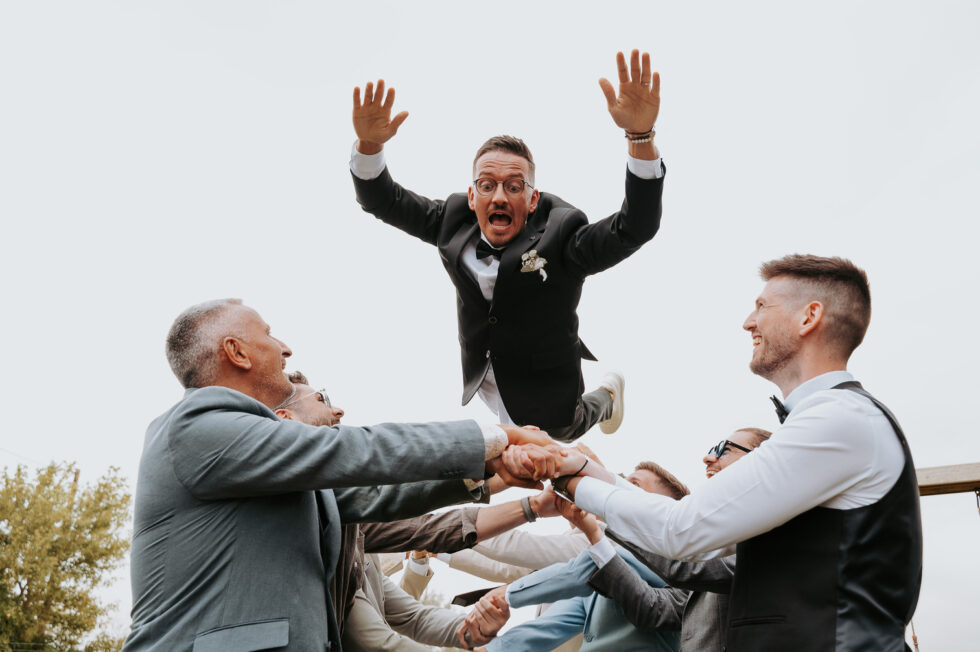 Le marié est jeté haut dans les airs par ses témoins et garçons d'honneur, expression de joie et de frayeur.