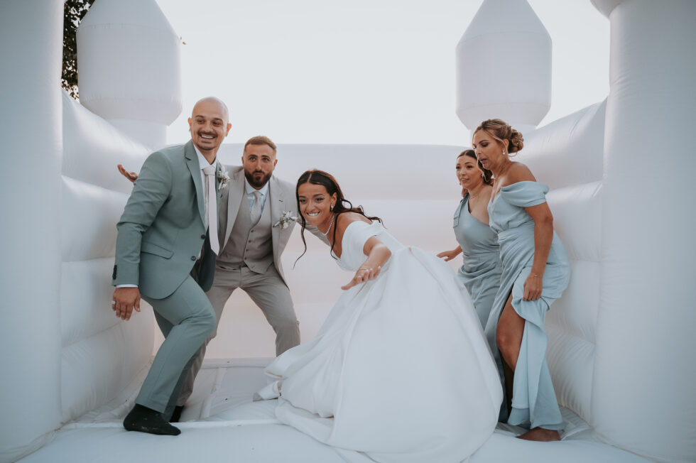 Mariés et leurs amis s'amusant dans un château gonflable blanc lors d'un mariage dans le Nord Pas-de-Calais, photographié par Benoit Delattre.
